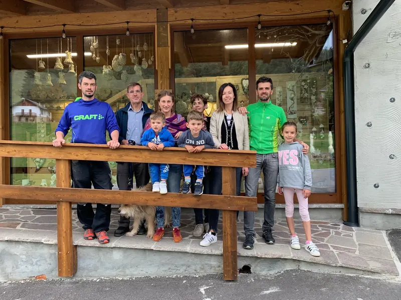 La famiglia Gusat davanti al negozio di artigianato in legno